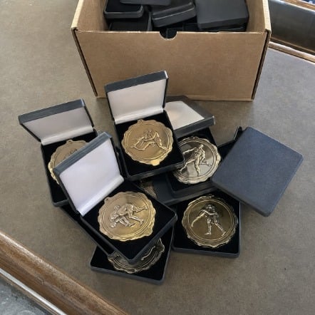 Championship wrestling medals in presentation cases