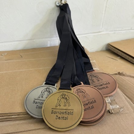 Personalized wrestling award medals on a wall hook